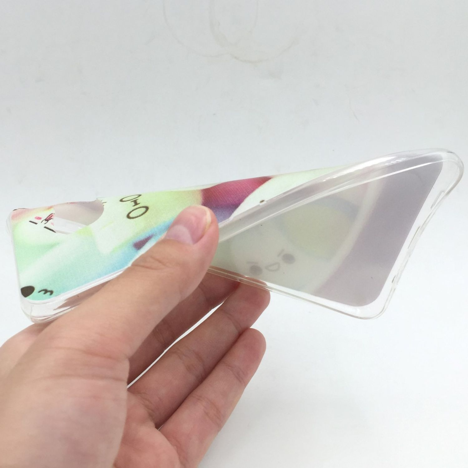 Eine Hand hält eine transparente Handyhülle mit Cartoon-Design, zeigt Gesichter.