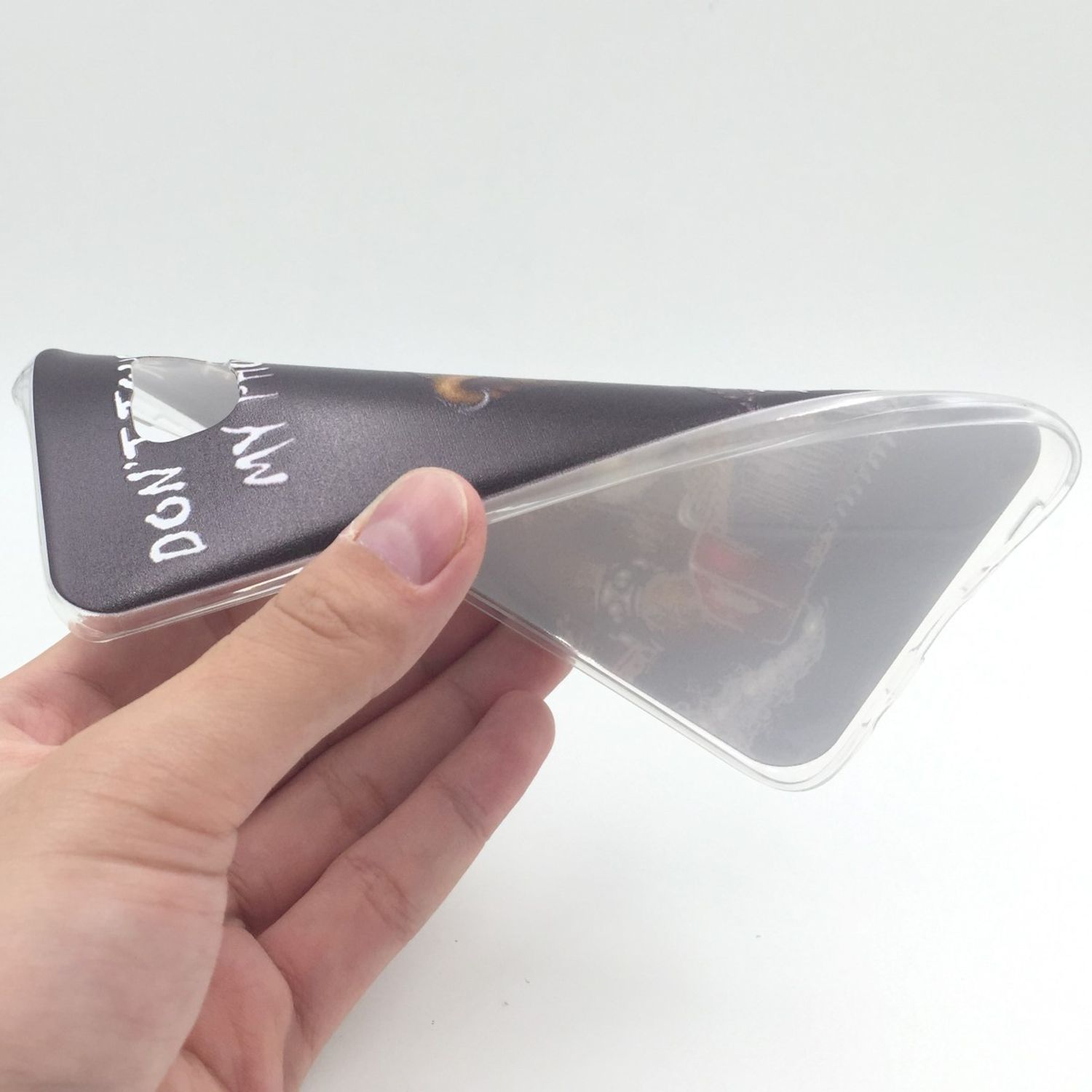 Eine Handyhülle mit Schriftzug, die teilweise ein Telefon verdeckt, gehalten von einer Hand.