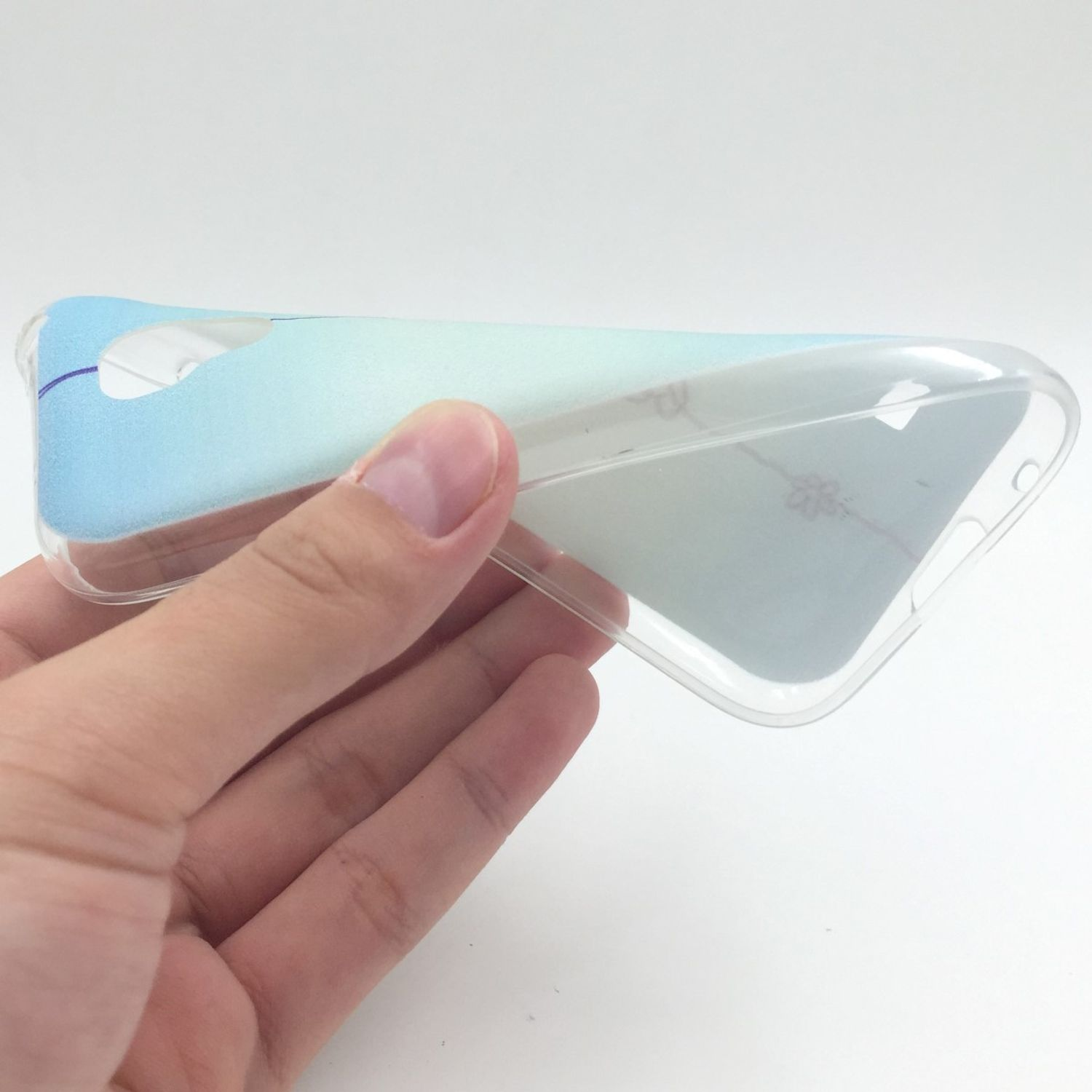 Eine Hand hält eine transparente Handyhülle und zeigt ein Gradienten-Design auf weißem Hintergrund.