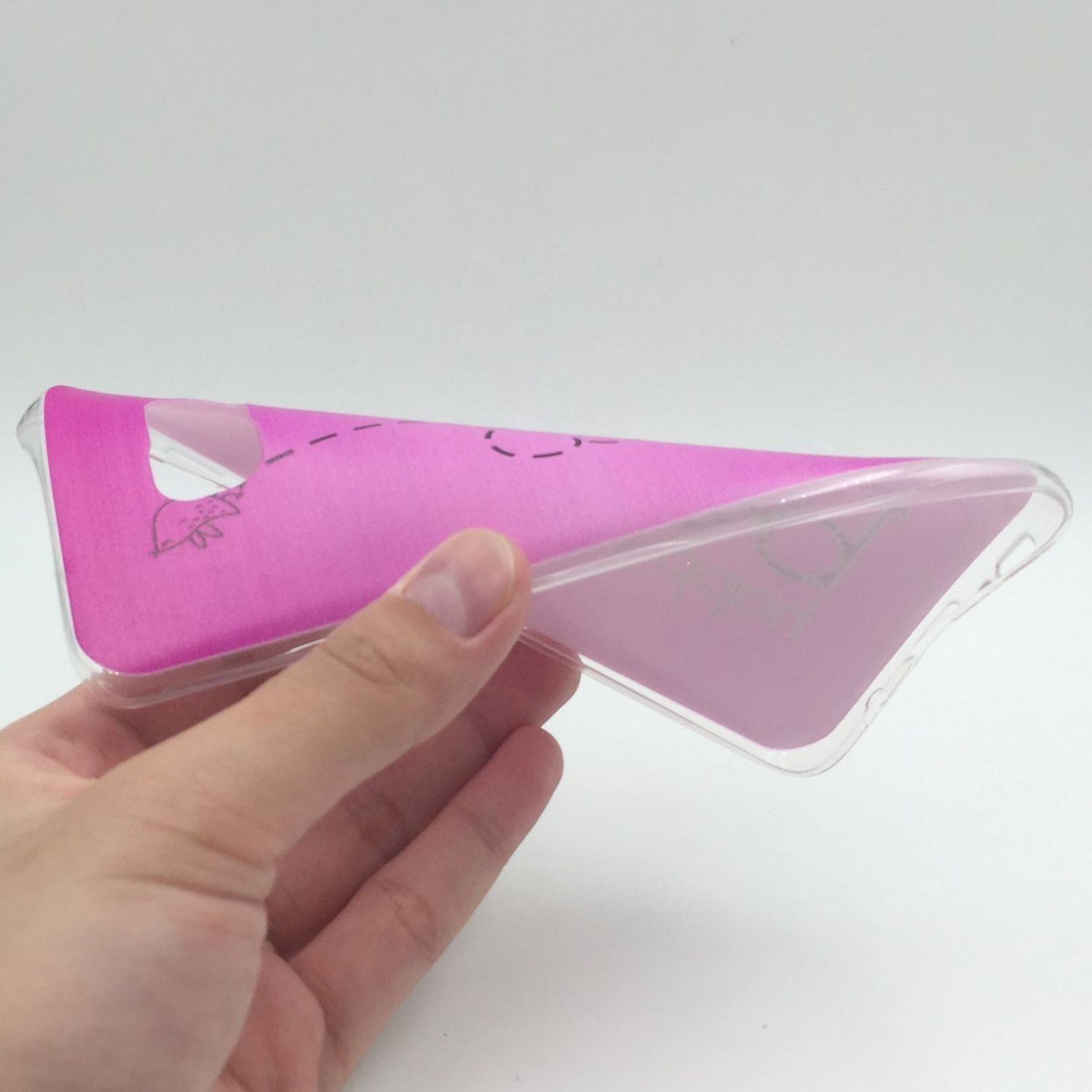 Eine Hand, die eine transparente Handyhülle mit pinkem Design auf weißem Hintergrund hält.