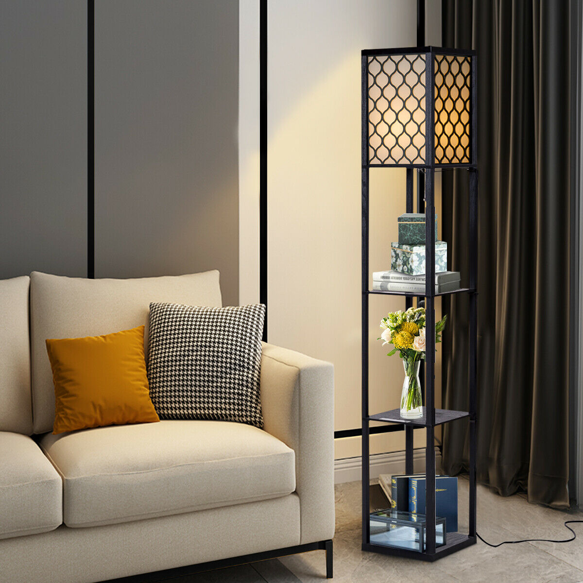 Eine schwarze Stehlampe mit Regalen, einer Vase, einer Couch und Kissen.