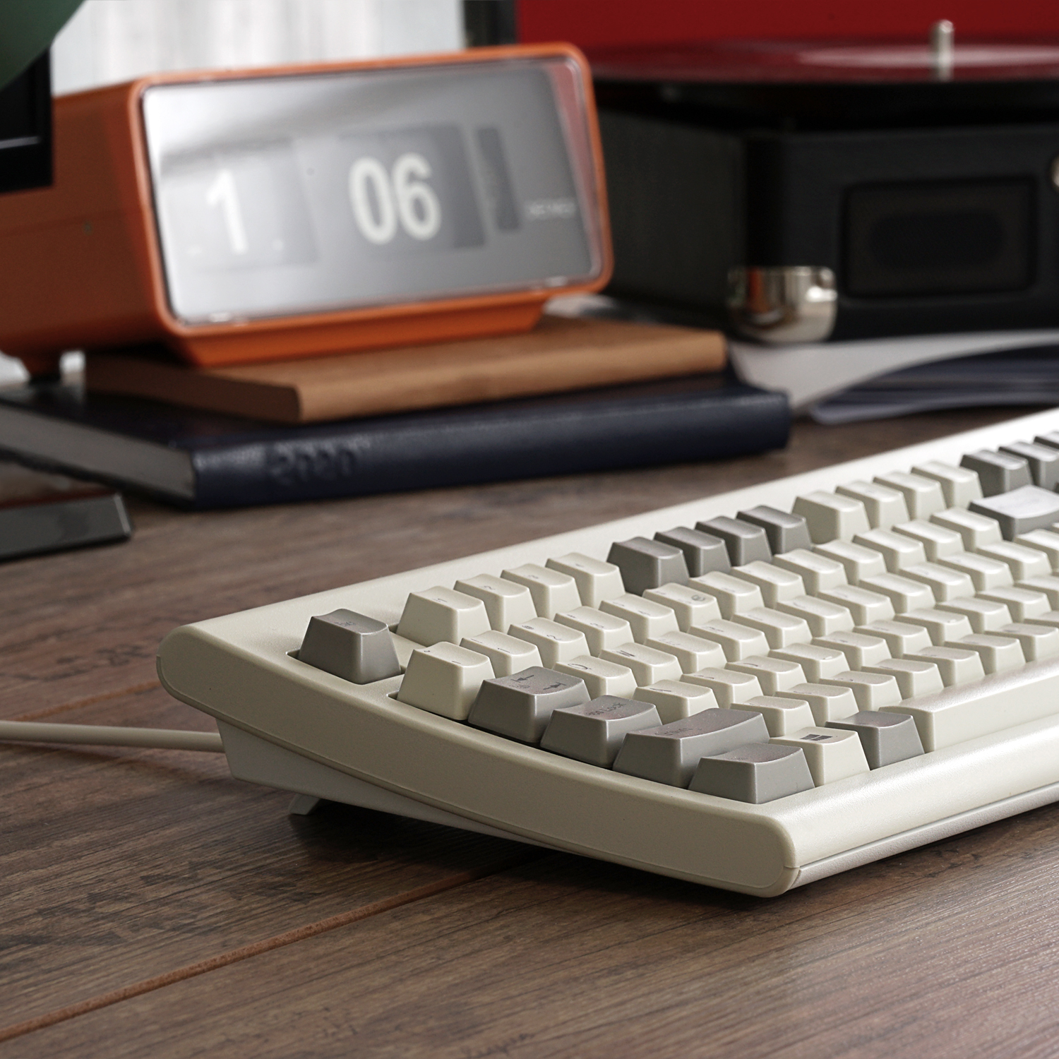 Vintage Wecker, Tastatur und Bücher auf Holzoberfläche. Verschwommener Hintergrund.
