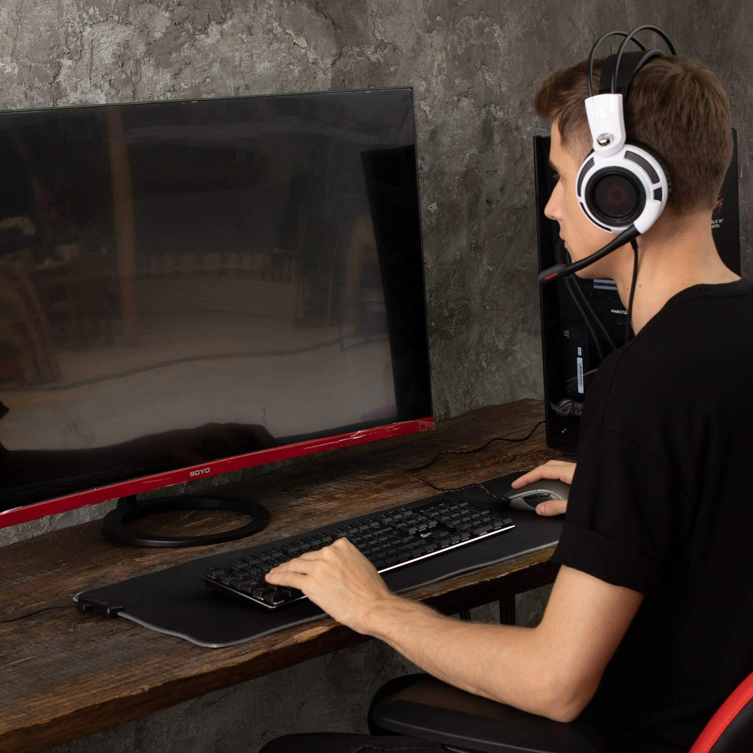 Mann mit Headset, der Tastatur und Maus benutzt.