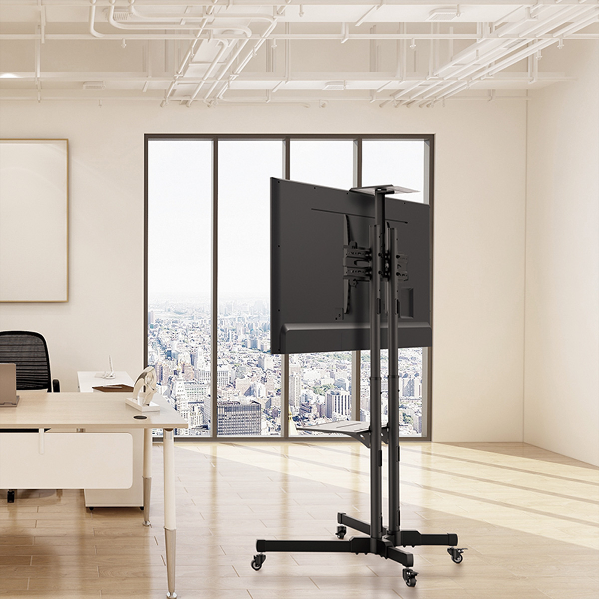 Un televisor negro sobre un soporte en una oficina, con una ventana y vista de la ciudad al fondo.
