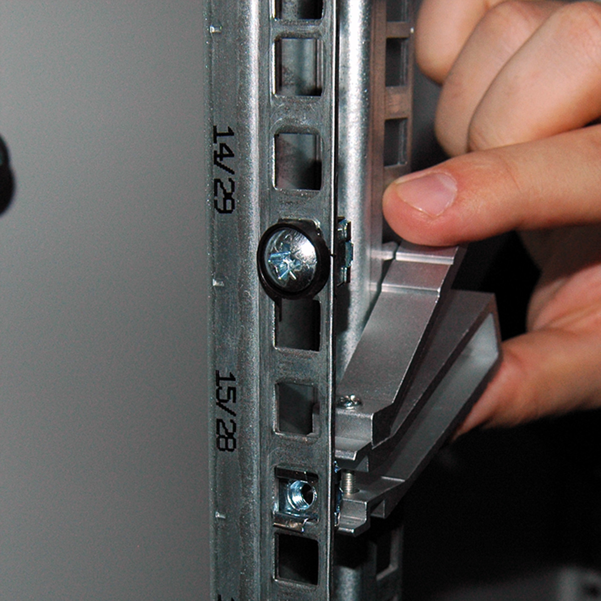 Una mano sta installando una staffa metallica in un rack server.