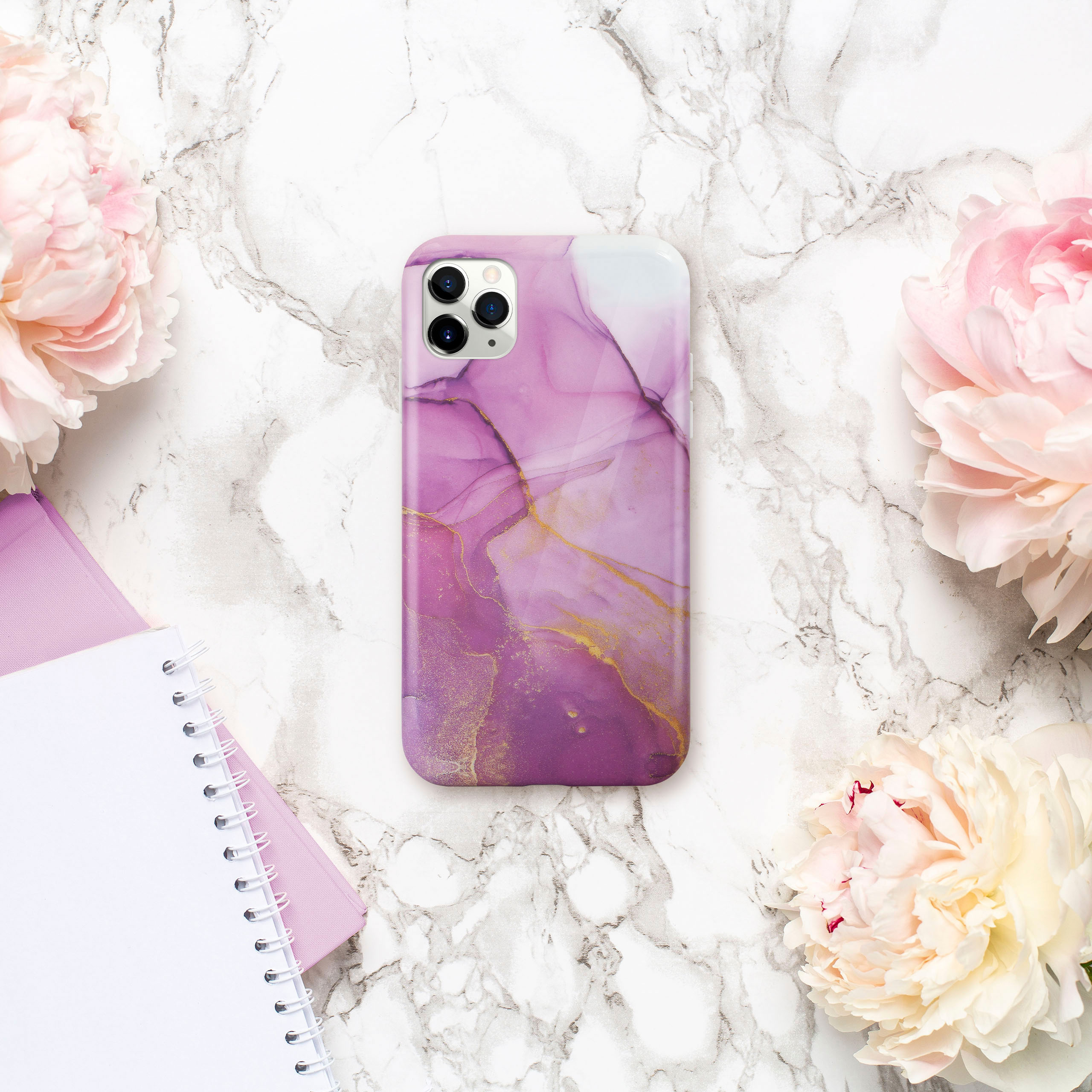 Handyhülle mit lila und goldenem Marmordesign, mit rosa Blumen und einem weißen Notizblock.