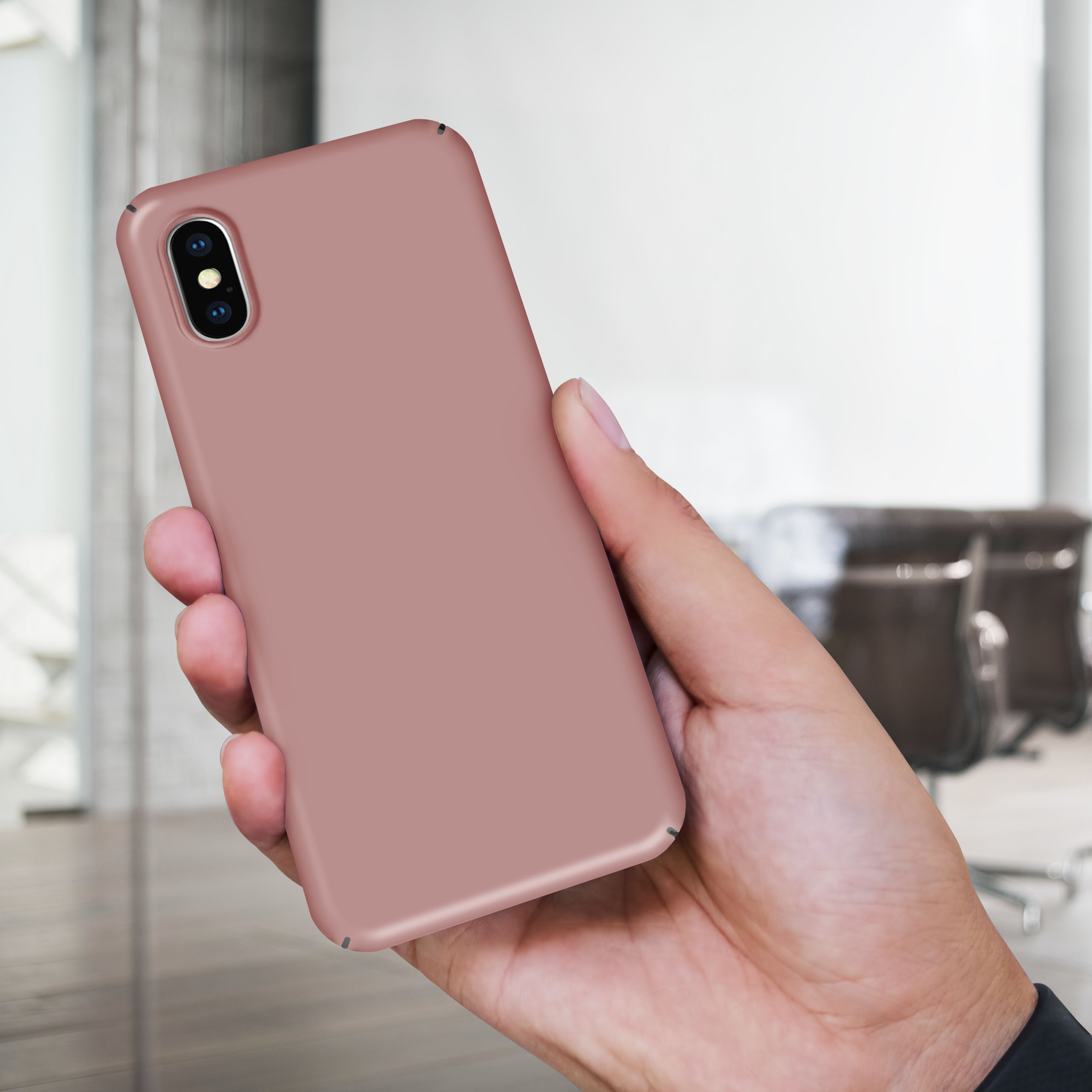 Hand hält eine rosa Handyhülle. Der Hintergrund ist eine verschwommene Büroumgebung. Die Handyhülle sieht neu aus.