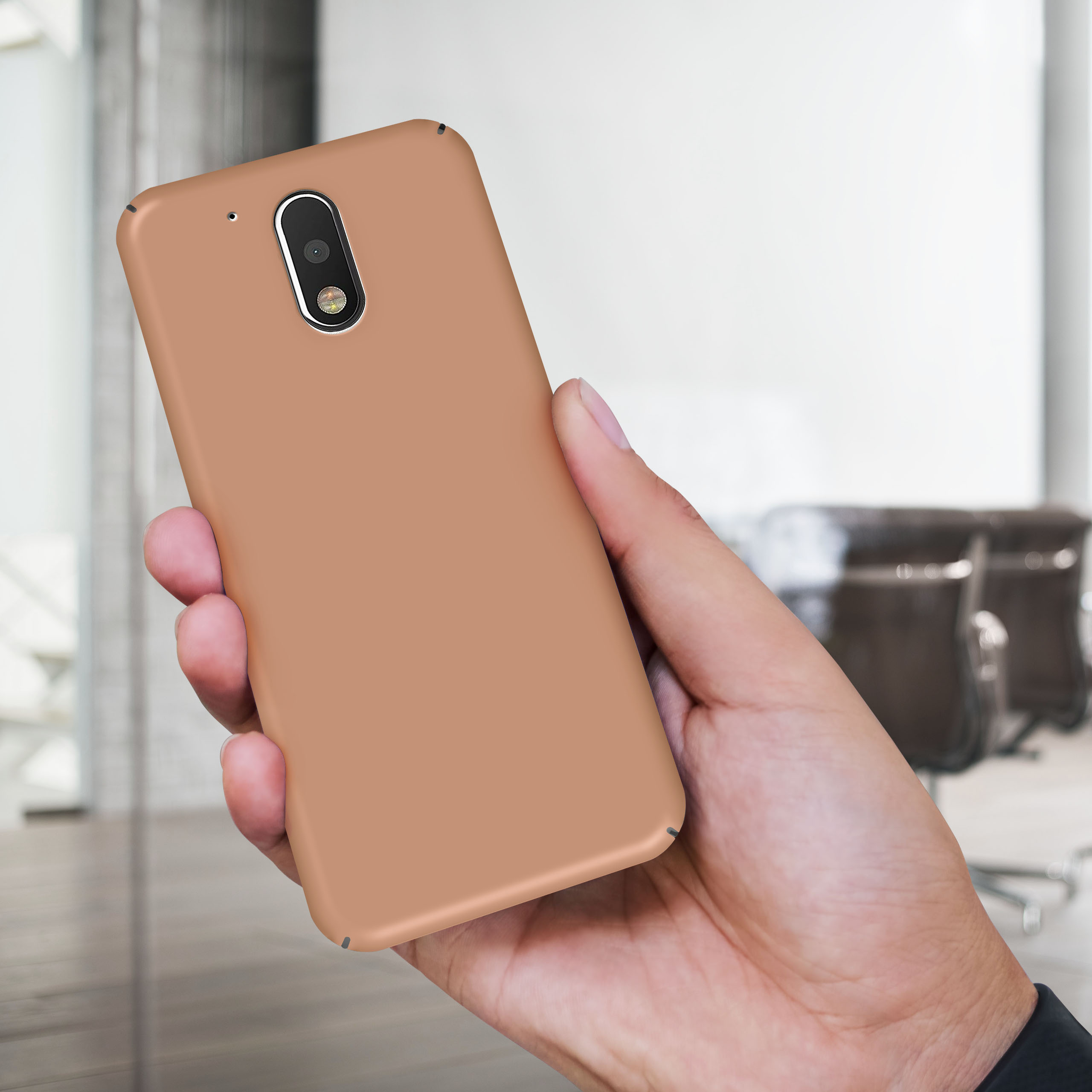 Eine Hand, die ein Telefon mit einer braunen Hülle hält. Der Hintergrund ist verschwommen.