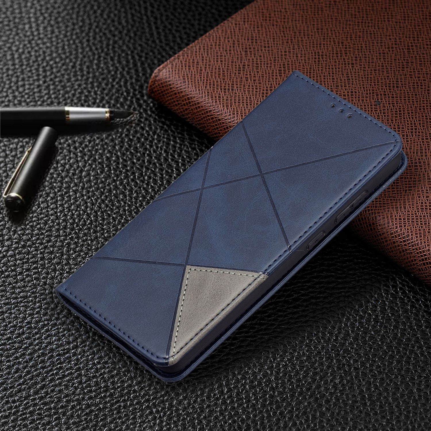 Blaue Handyhülle mit geometrischem Design. Die Hülle liegt auf einer Lederoberfläche. Ein Stift liegt neben der Hülle.