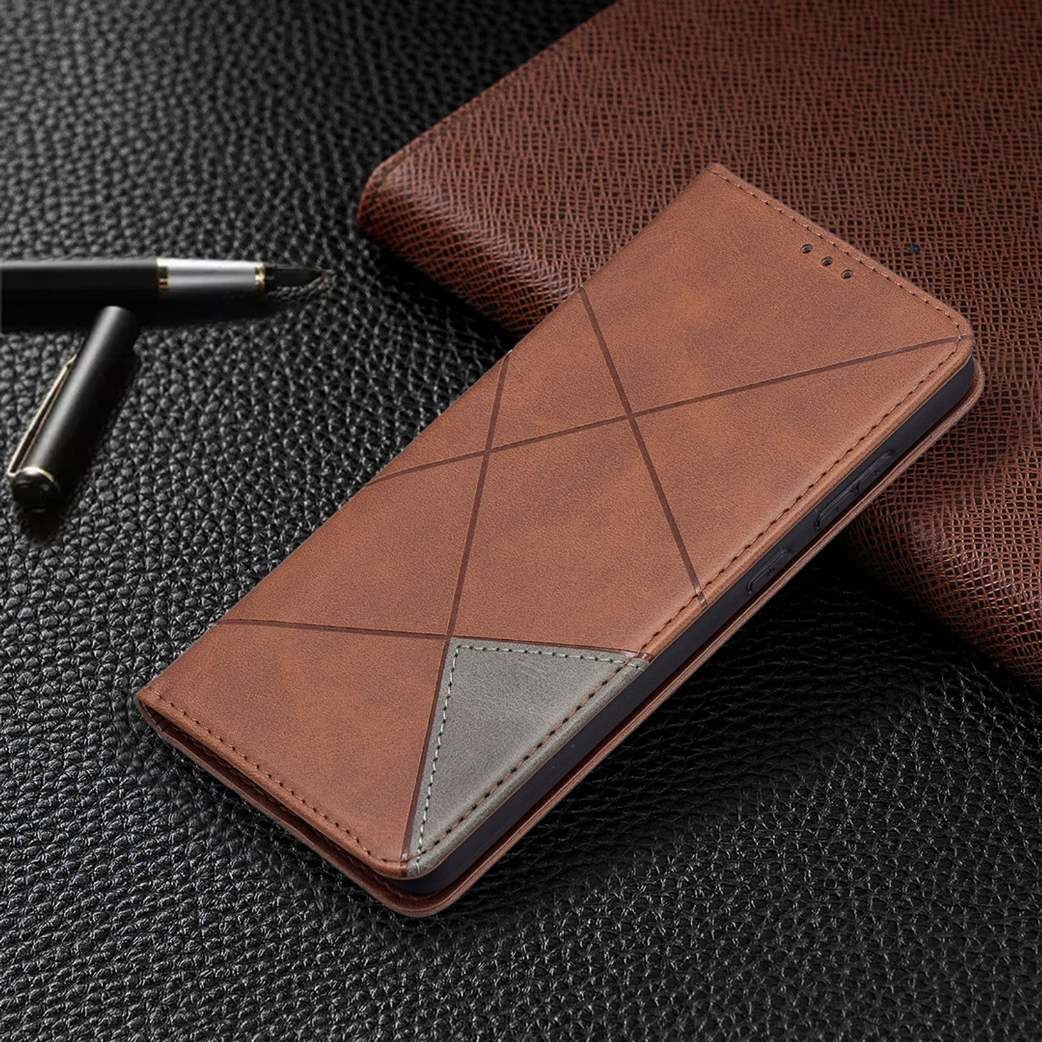 Eine braune Handyhülle mit geometrischem Muster und ein Stift auf dunkler Oberfläche.