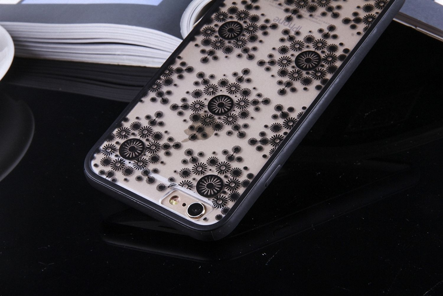 Eine Handyhülle mit floralem Design auf schwarzem Hintergrund, die die Kamera des Telefons zeigt.