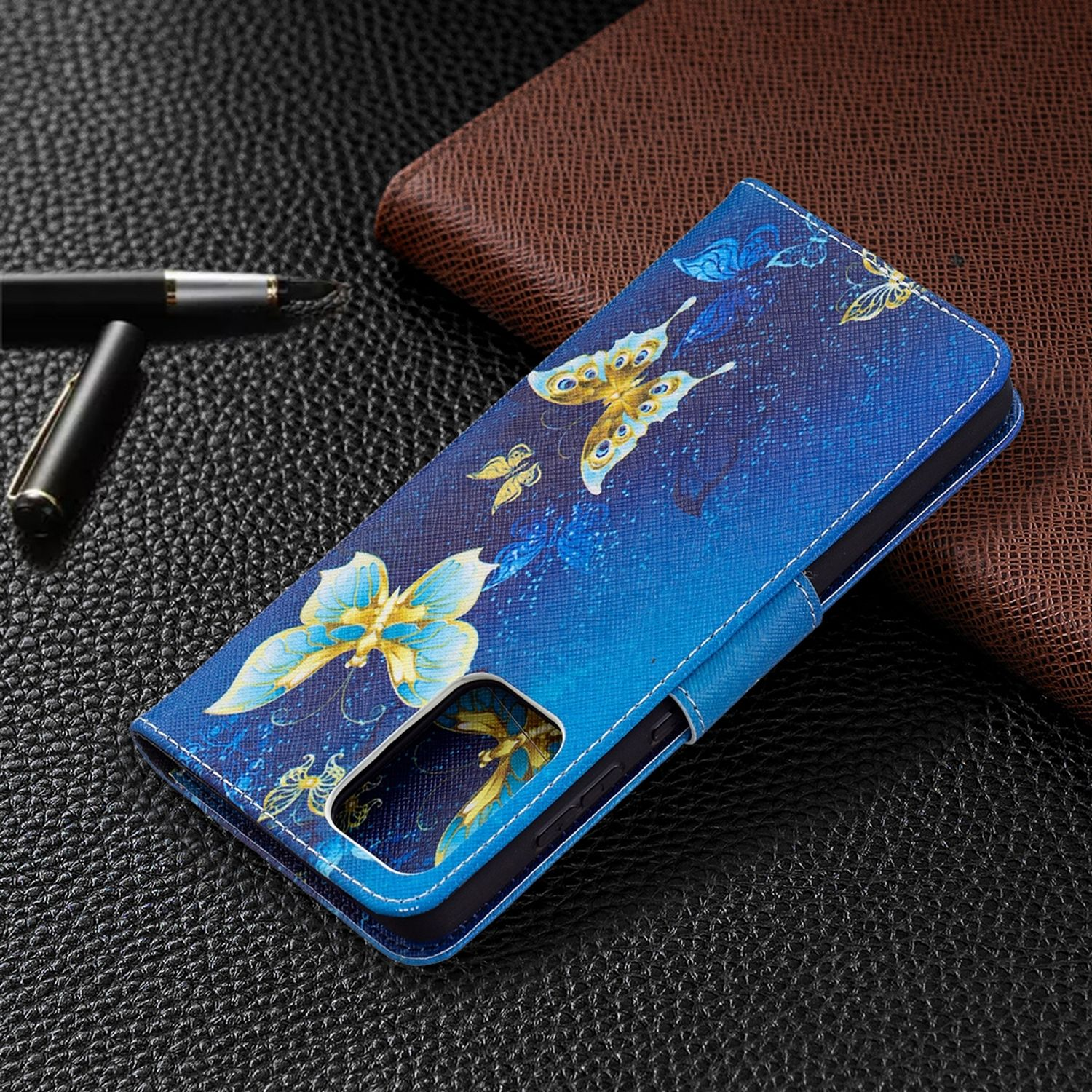 Blaue Handyhülle mit Schmetterlingsdesign. Die Hülle liegt auf Leder. Auch ein Stift ist sichtbar.