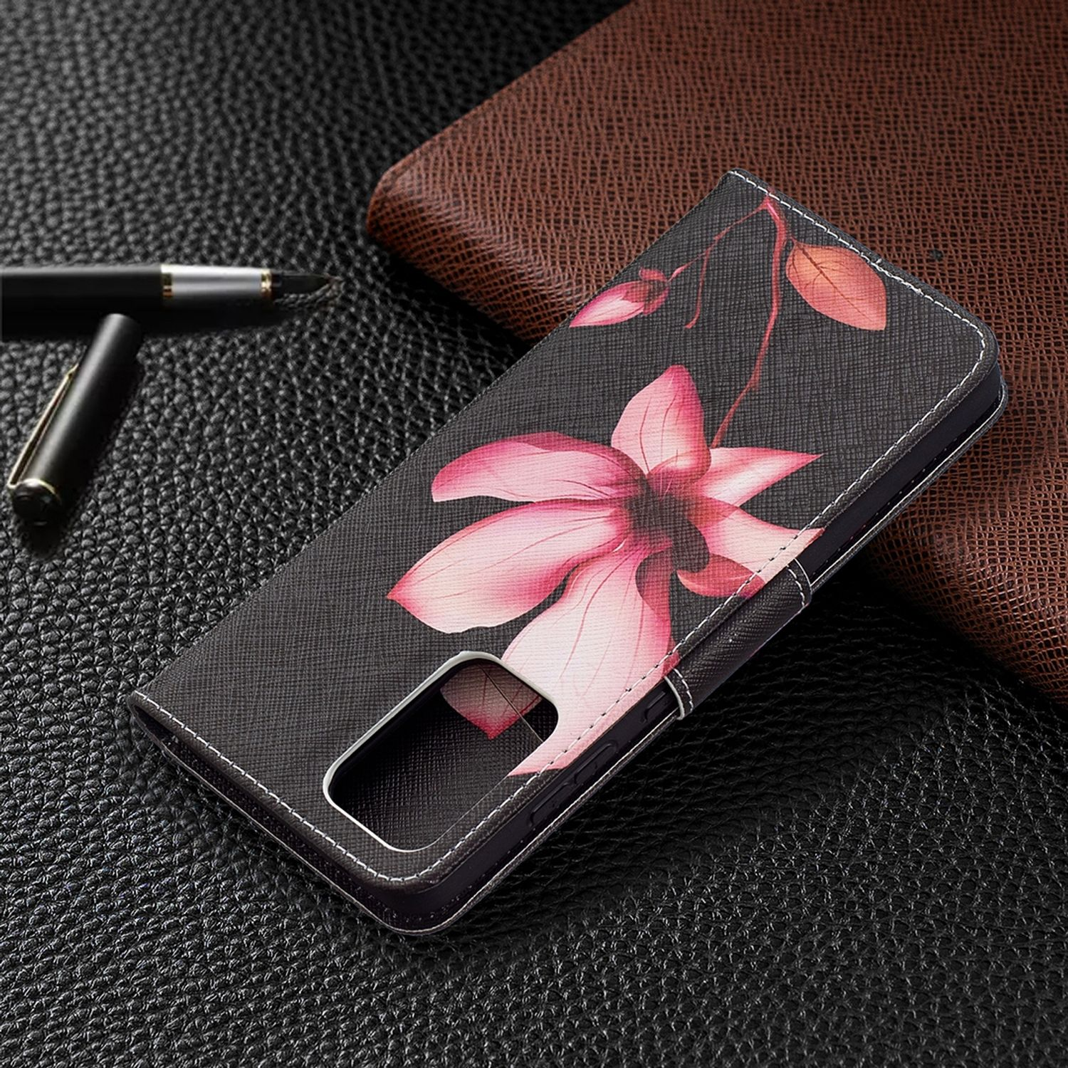 Eine schwarze Handyhülle mit einem rosa Blumendesign, platziert auf einer strukturierten Oberfläche.