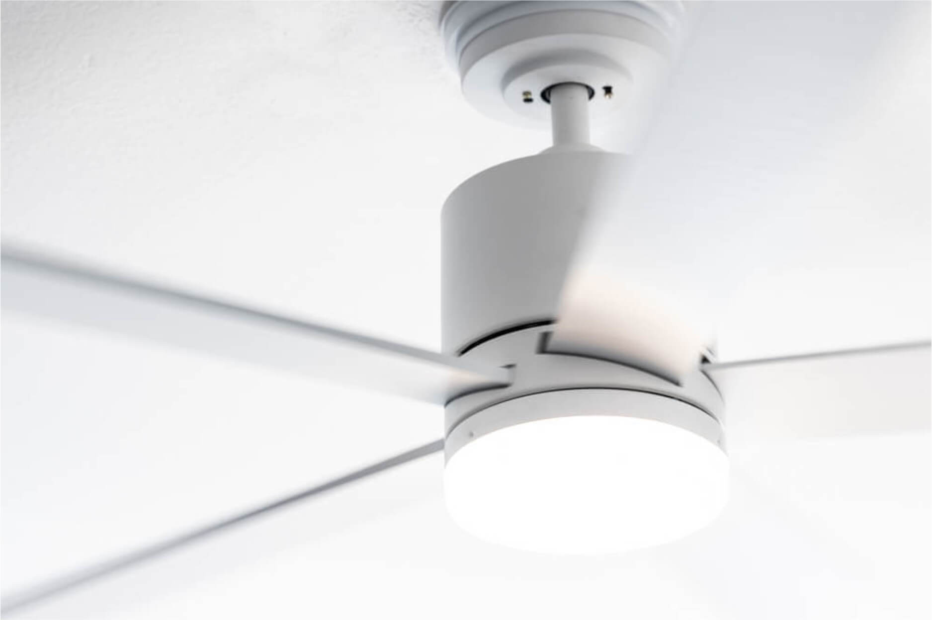 Deckenventilator mit weißen Flügeln und einer Leuchte.