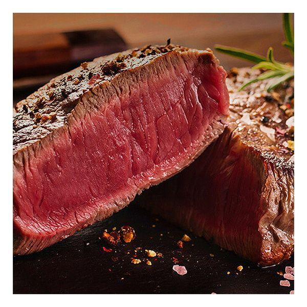 Bistecca a fette, che mostra l'interno rosso, su una superficie scura con spezie.