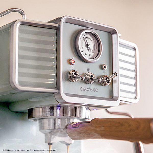 Zbliżenie na ekspres do kawy w stylu retro. Ma przełączniki i wskaźnik. Tło białe.