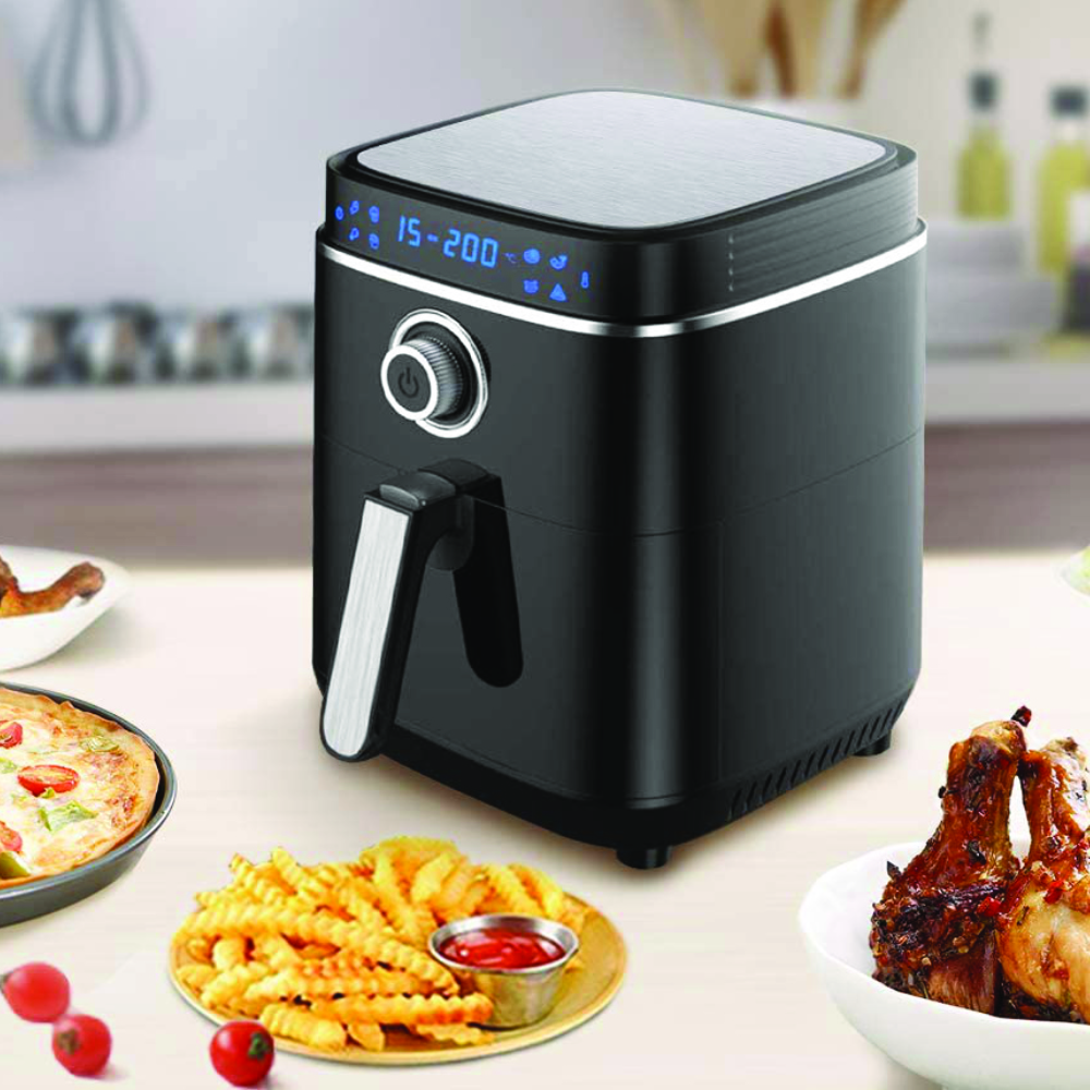 Eine schwarze Heißluftfritteuse mit Digitalanzeige, Pommes und Hähnchen auf einem Tisch.