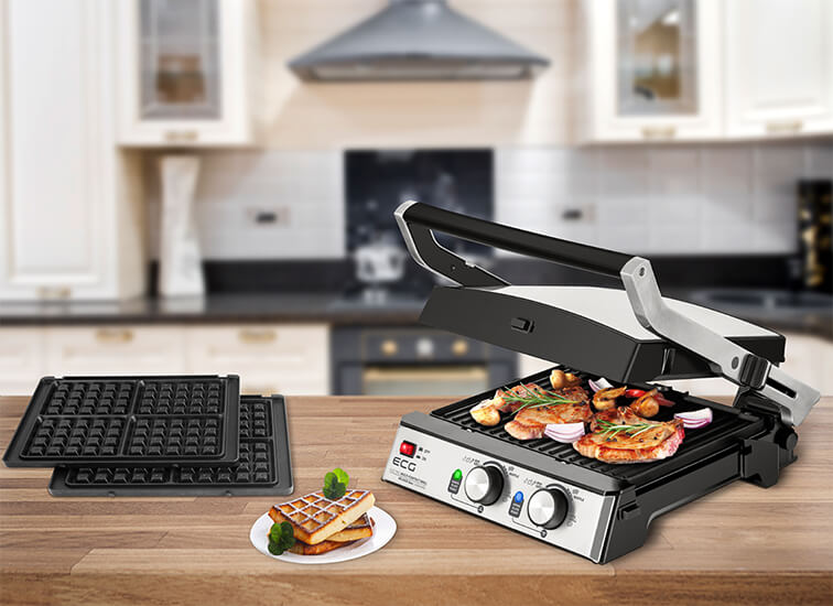 Grill z jedzeniem. Gofry i inne przedmioty znajdują się na stole przed nim.