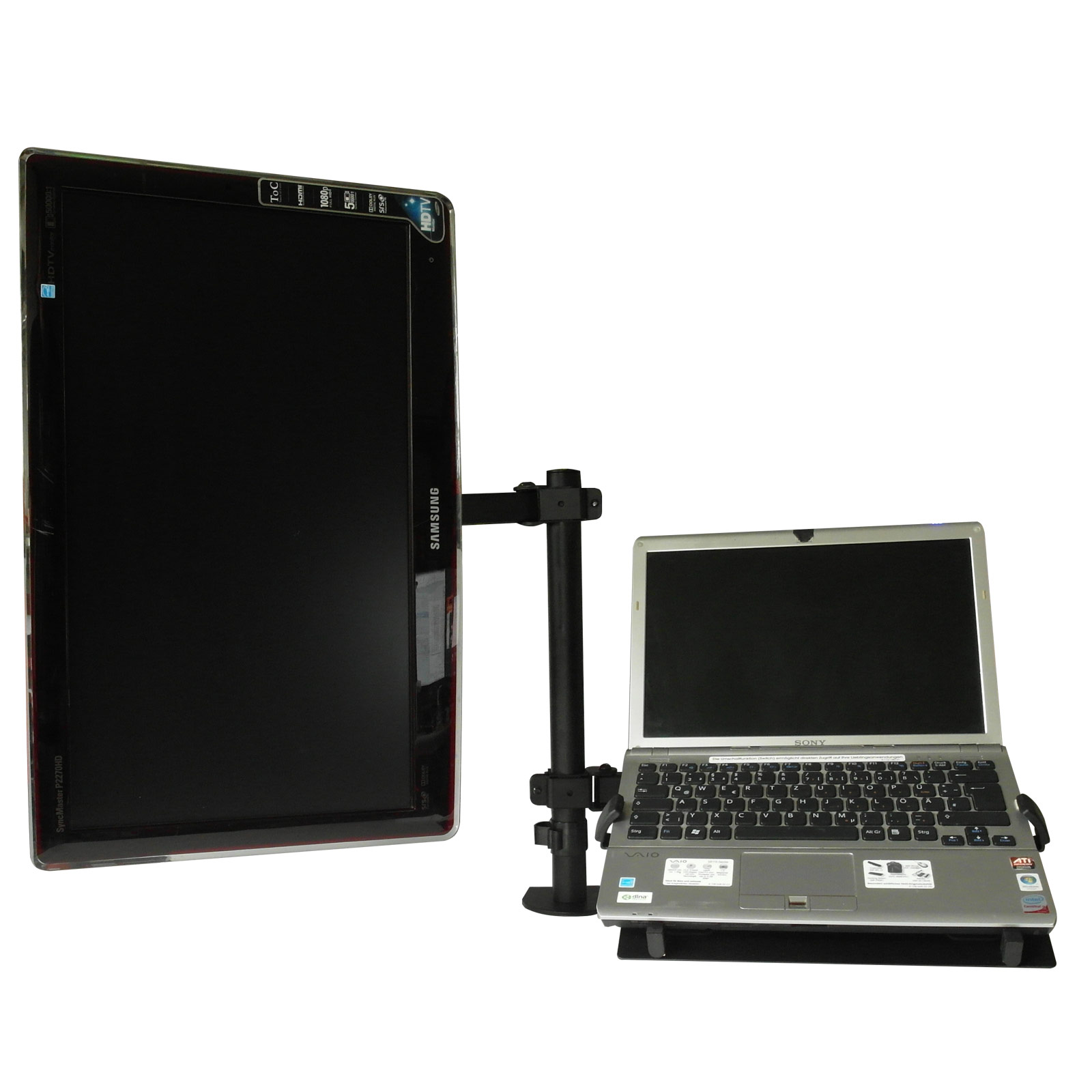 Ein Monitor und ein Laptop sind mit einer schwarzen Halterung verbunden, vor weißem Hintergrund.