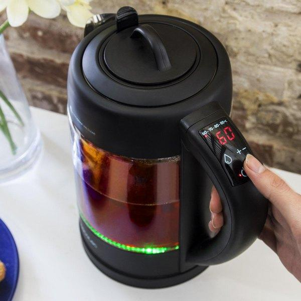 Una tetera negra con una pantalla digital que muestra 60. Una mano sostiene el asa.