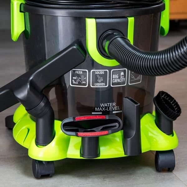 Black and green vacuum cleaner with a nozzle and several attachments. Close up.
