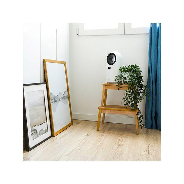 Mała drewniana drabina z białą oczyszczaczem powietrza i roślinami. Obrazy w ramkach oparte o ścianę.