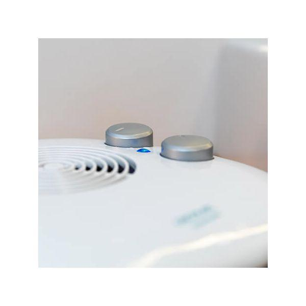 Zbliżenie białego urządzenia z dwoma srebrnymi pokrętłami i małym niebieskim światłem.