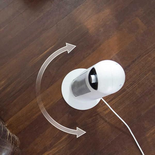 Ventilador blanco giratorio en suelo de madera con flechas.