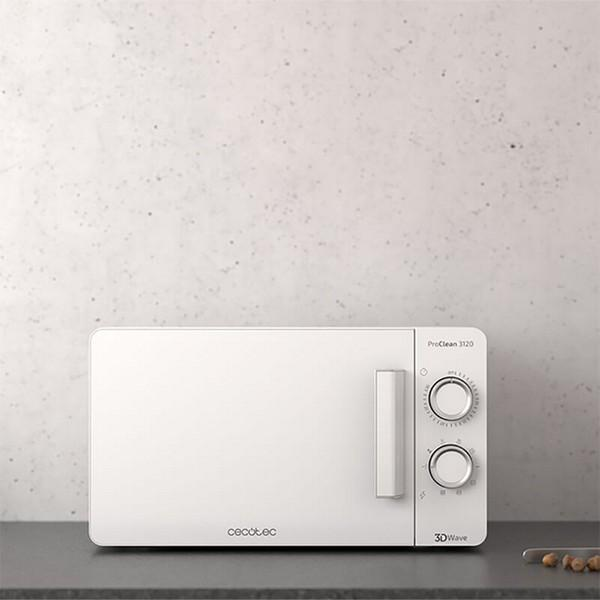 Biała kuchenka mikrofalowa z dwoma pokrętłami na szarym blacie, na tle jasnoszarej ściany.