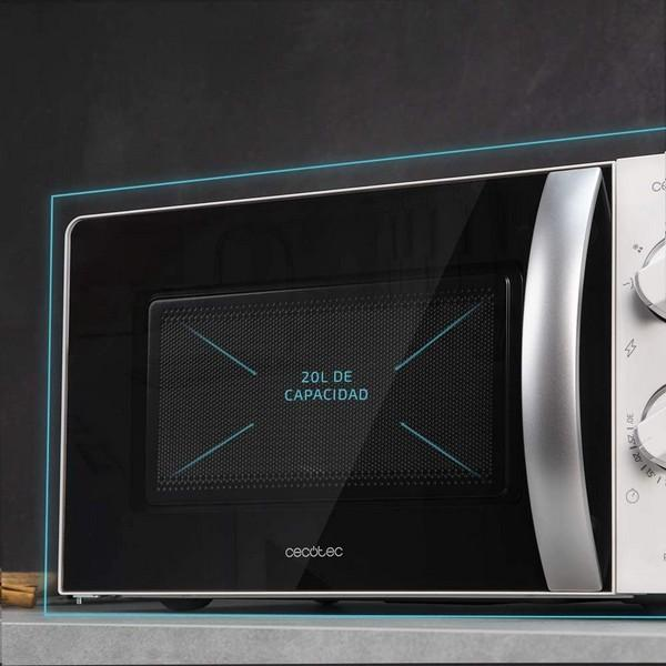Czarna kuchenka mikrofalowa ze szklanymi drzwiami. Tekst na drzwiach: 20L DE CAPACIDAD.