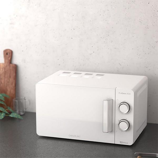 Biała kuchenka mikrofalowa na blacie kuchennym. Kuchenka mikrofalowa ma dwa pokrętła i uchwyt. Tło jest białe.