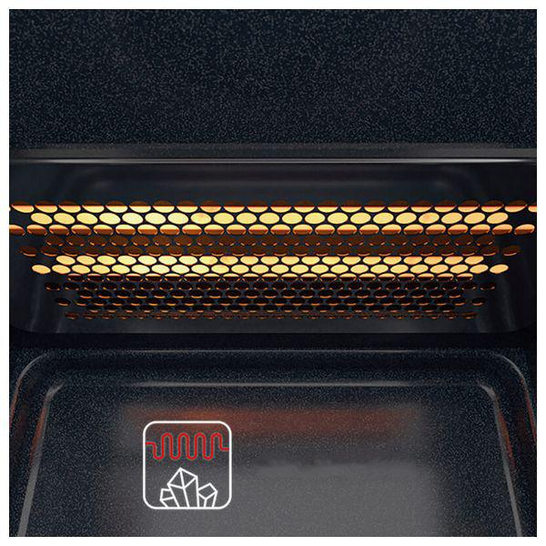 Zbliżenie wnętrza piekarnika z podgrzewanym rusztem. Piekarnik jest ciemny, ruszt świeci na pomarańczowo.