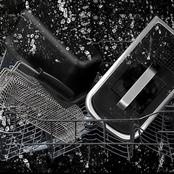 Naczynia myte w zmywarce. Woda spryskuje druciany kosz i inne przedmioty.