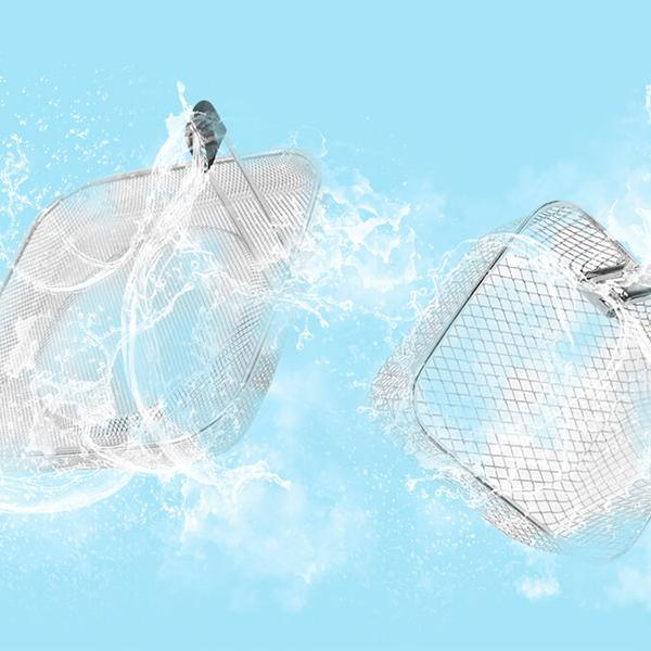 Dwa metalowe kosze z siatki spryskane wodą na jasnoniebieskim tle, widoczne krople.