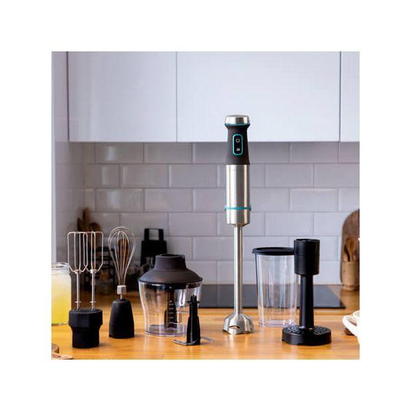 Een blender en accessoires op een houten aanrecht in een keuken.