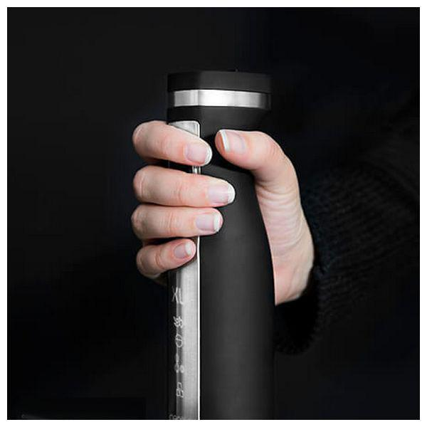 Dłoń trzymająca czarny blender. Blender ma srebrny pasek i biały tekst.