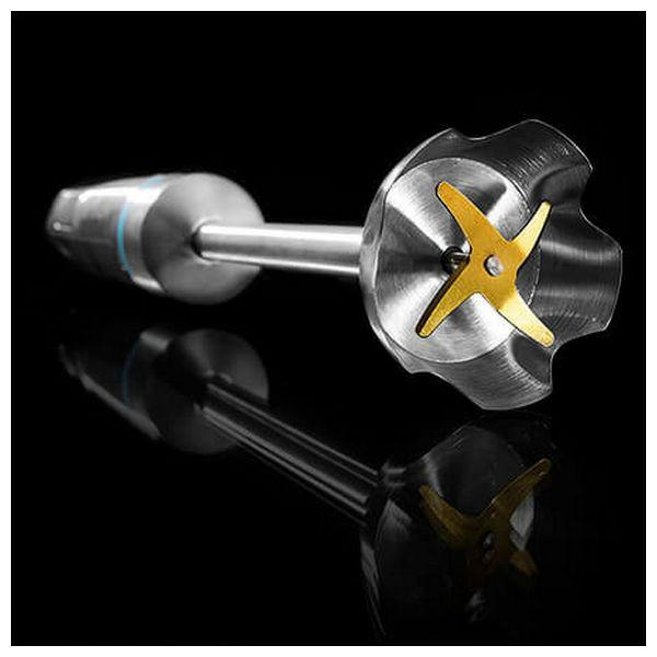 Srebrna i złota końcówka do blendera ręcznego z ostrzem w kształcie gwiazdy, odbijająca się na czarnej powierzchni.