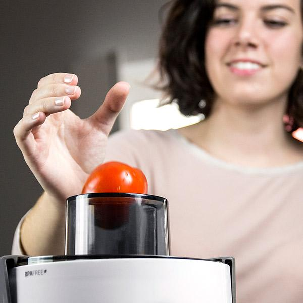 Una persona mette un pomodoro in una macchina nera. La macchina è bianca e nera.