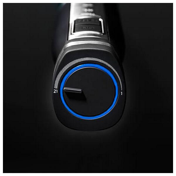 Primo piano di un regolabarba nero con un quadrante illuminato di blu che mostra le impostazioni da 1-21.