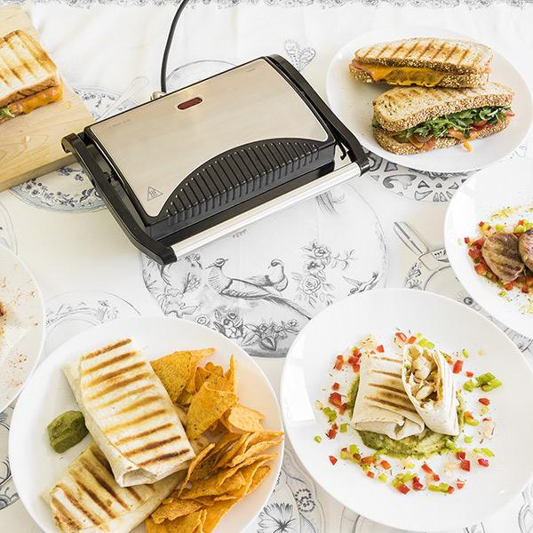 Różne potrawy na talerzach i grillu. Jedzenie obejmuje kanapki i wrap.