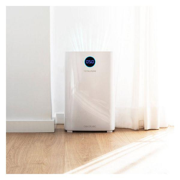 Purificatore d'aria bianco con display digitale e pavimento in legno, vicino a un muro.