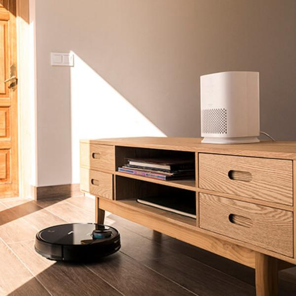 Robot aspirapolvere e purificatore d'aria su un mobile in legno. Scena di soggiorno moderno.