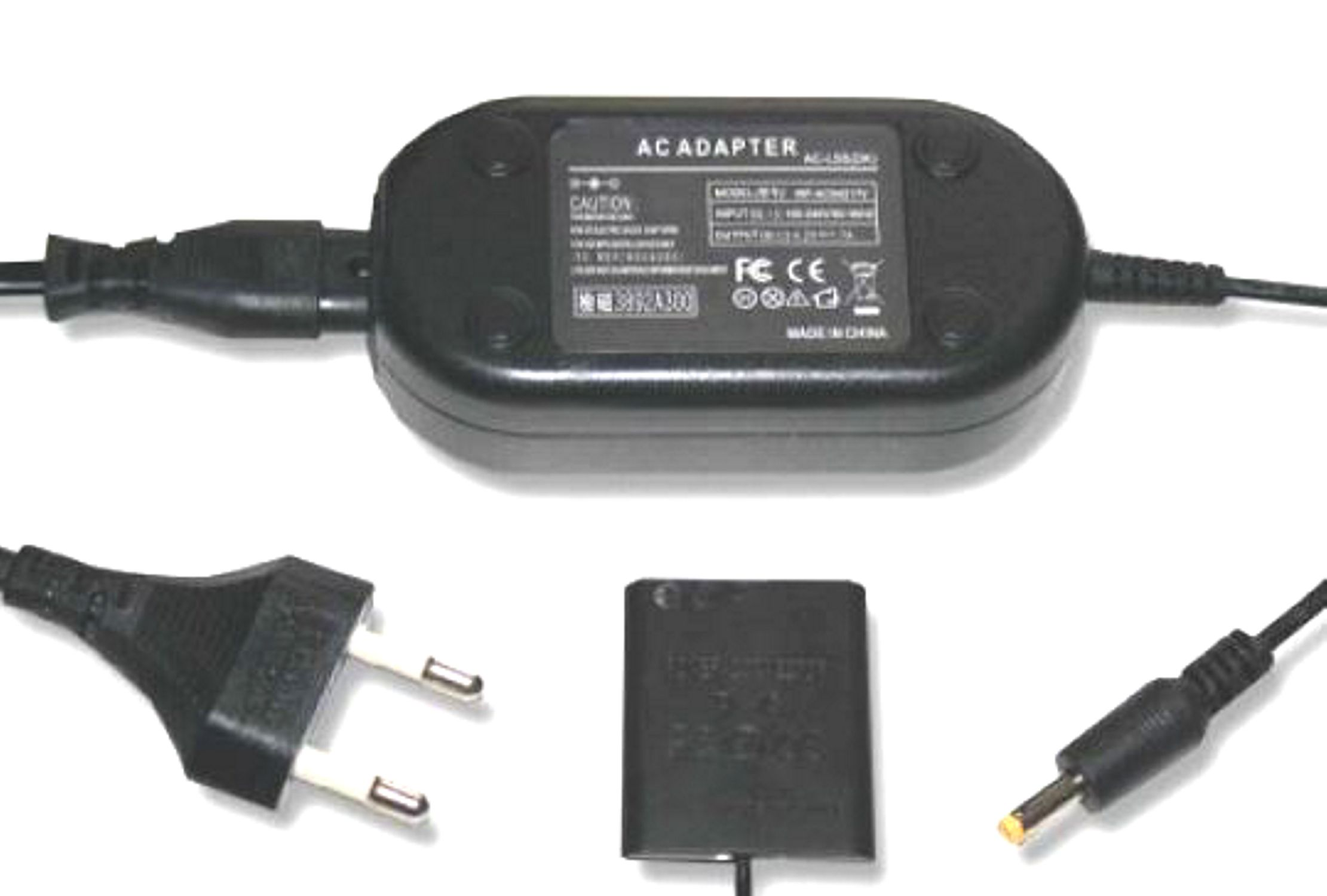 Ein schwarzes Netzteil mit einem schwarzen Stecker, einem kleinen schwarzen Batterieadapter und einem Gleichstromanschluss.