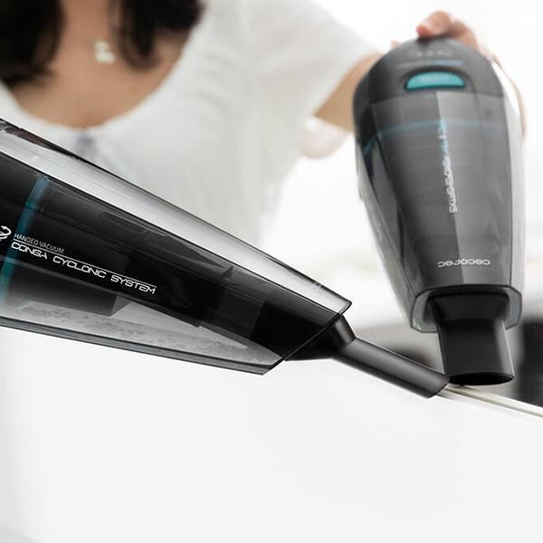 Aspirateur à main, corps noir avec des accents bleus.