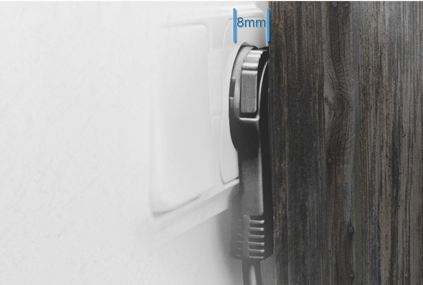 Eine Steckdose mit eingestecktem Ladegerät, die einen Abstand von 8 mm zur Wand zeigt.
