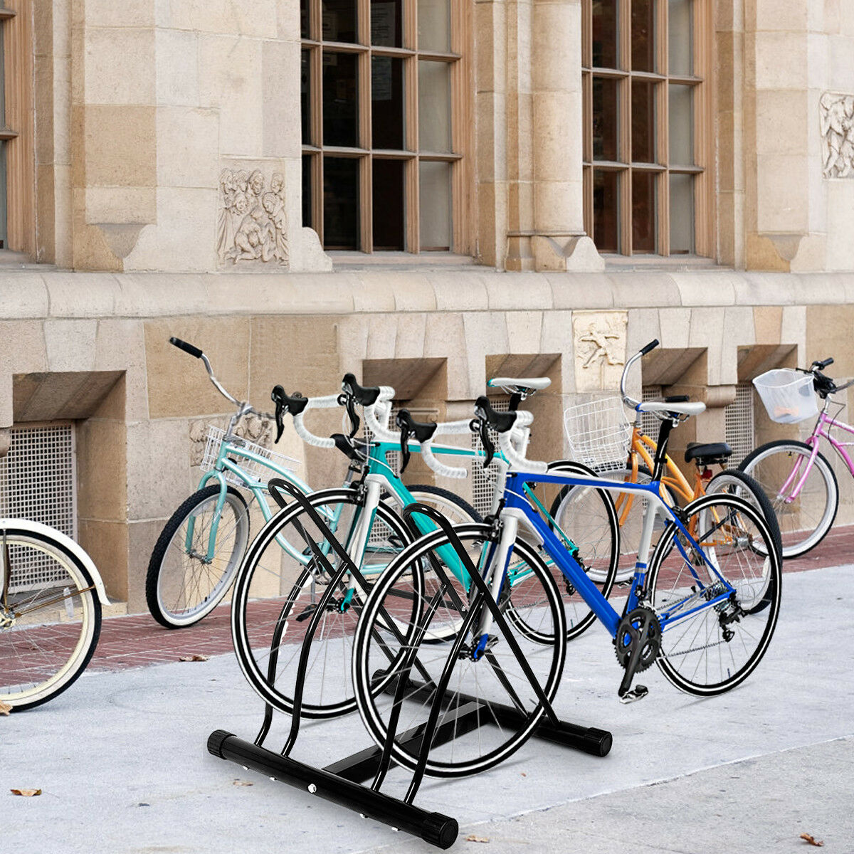 Fahrräder auf einem Fahrradständer vor einem Steingebäude geparkt. Verschiedene Farben und Stile.