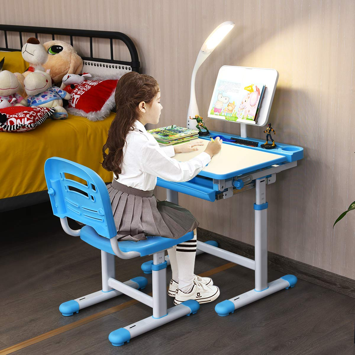Ein junges Mädchen sitzt an einem blauen Schreibtisch mit einer Lampe und lernt.