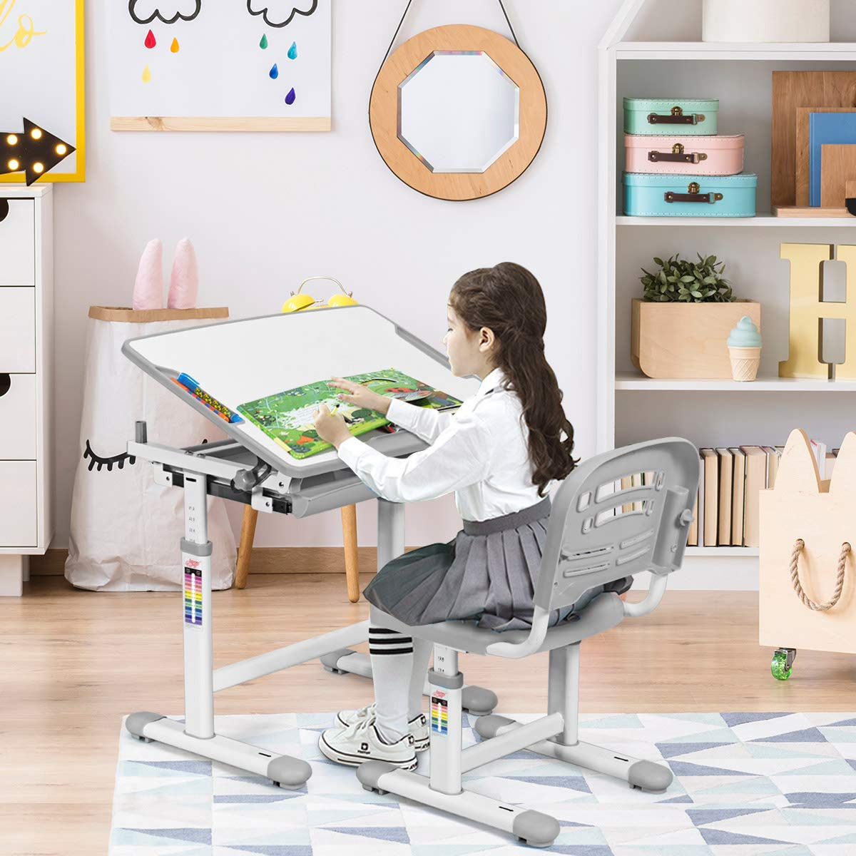 Ein Mädchen sitzt in einem Kinderzimmer an einem Schreibtisch und zeichnet. Der Tisch und der Stuhl sind verstellbar.