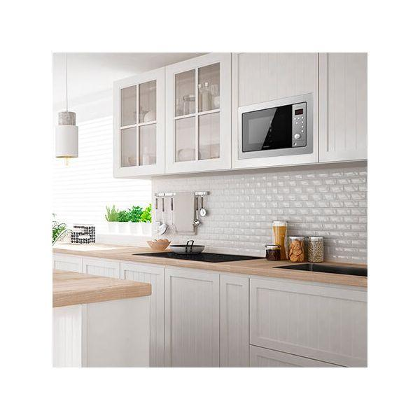 Kuchenka mikrofalowa wbudowana w szafkę kuchenną. Biała szafka i szare płytki.