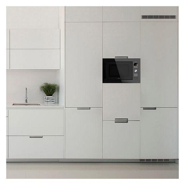 Nowoczesne białe szafki kuchenne z kuchenką mikrofalową i małą rośliną na blacie.